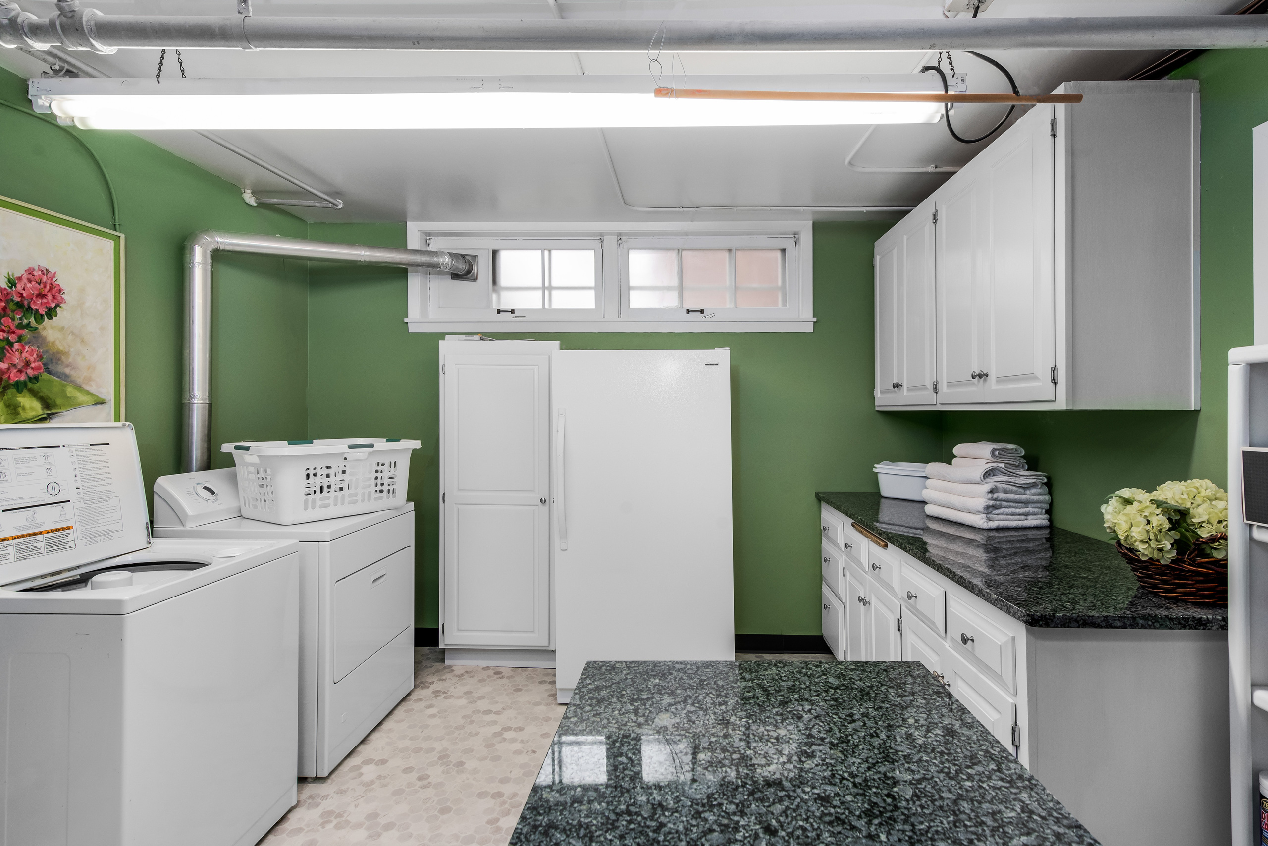 Classic cottage laundry room features a white and gray granite