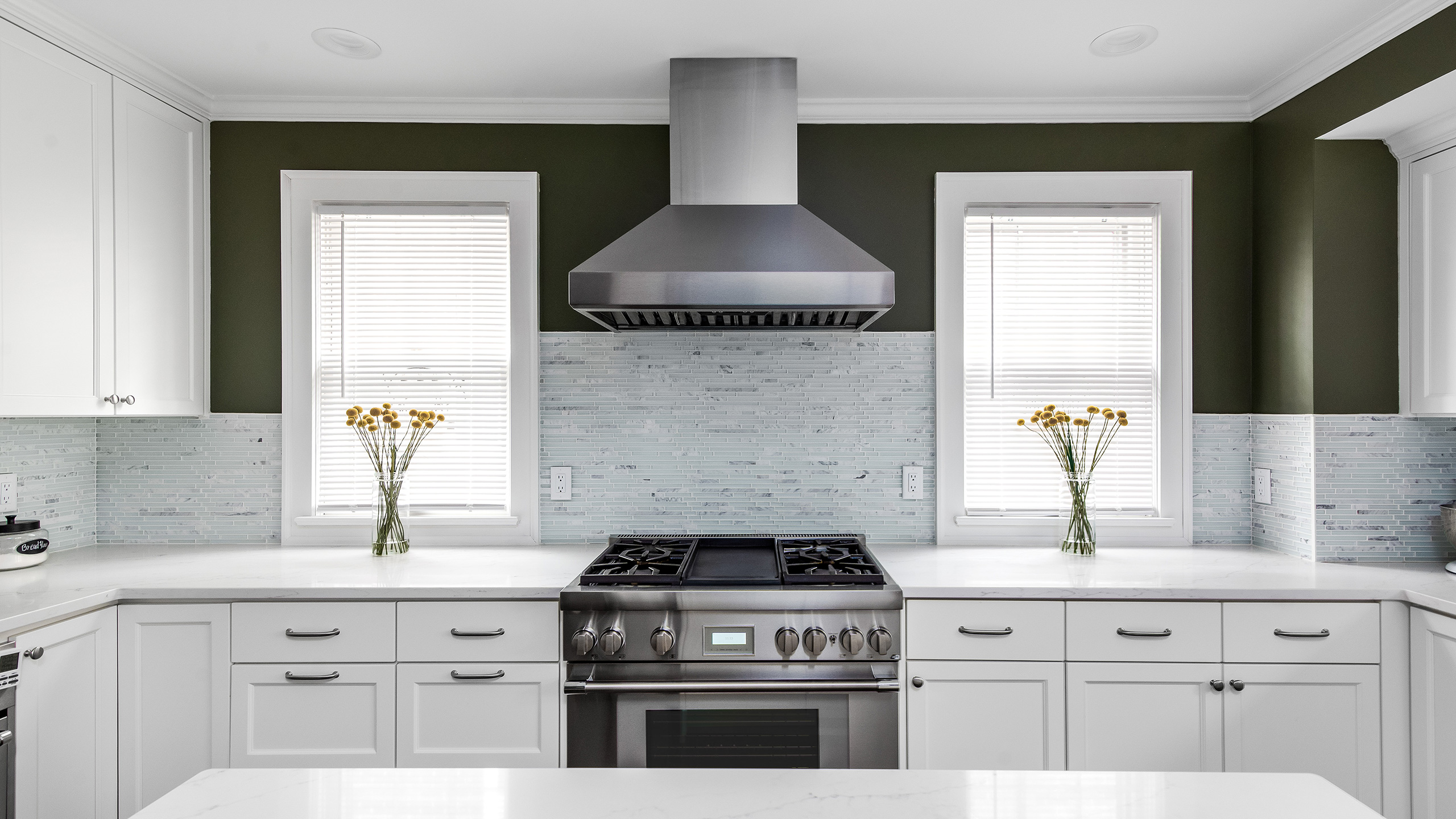 white and bright kitchen with stainless steel oven and range