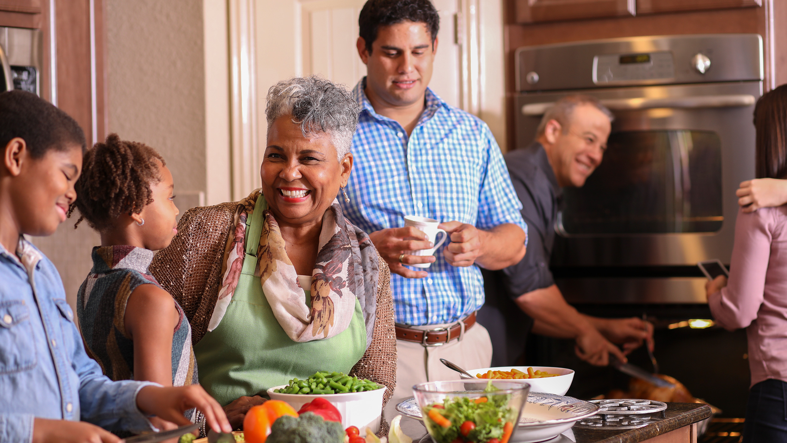 a multi-generation making a meal in the kitchen