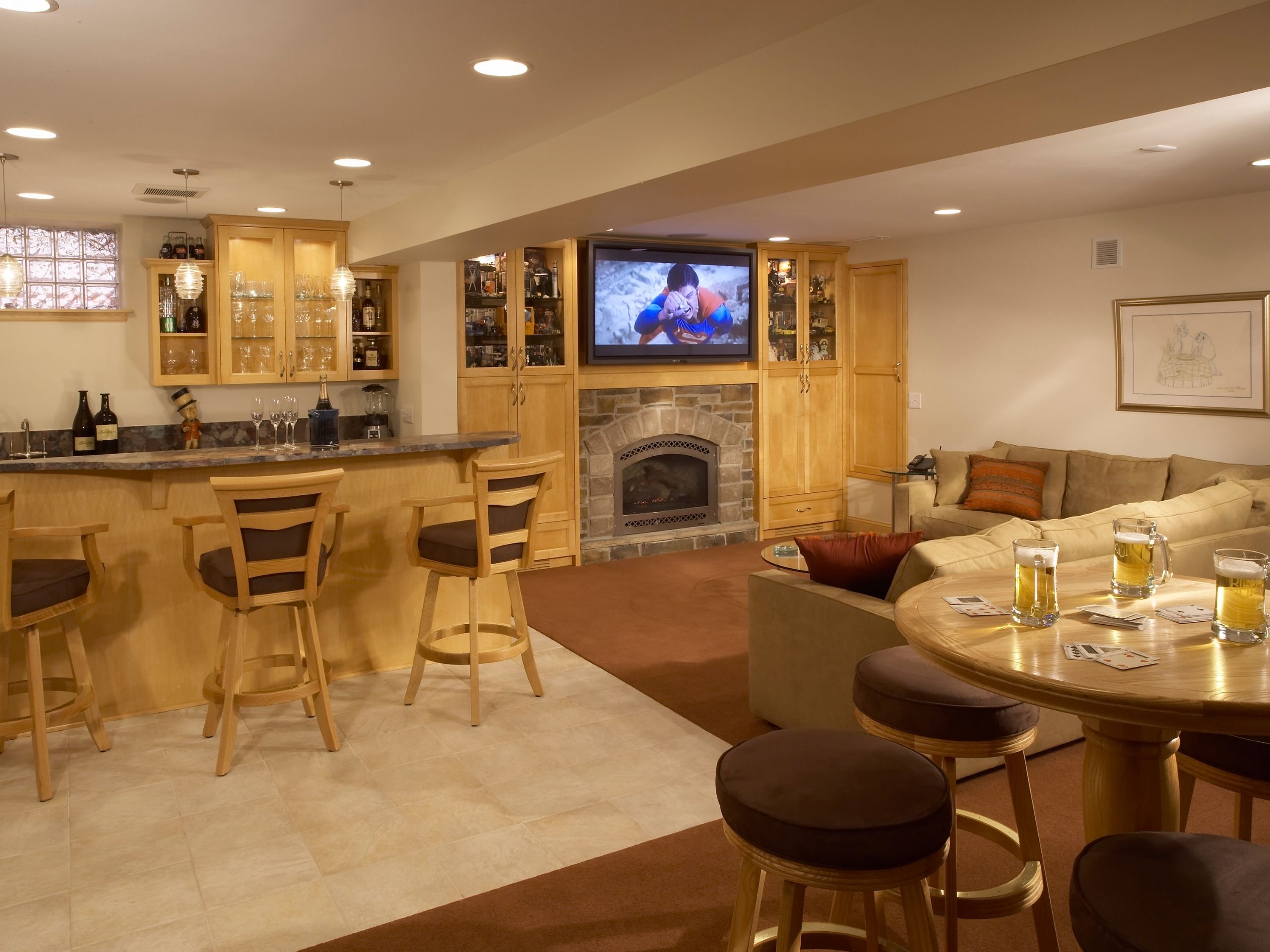 basement remodeling ideas: Basement bar and tv area with couch seating and beers on the table