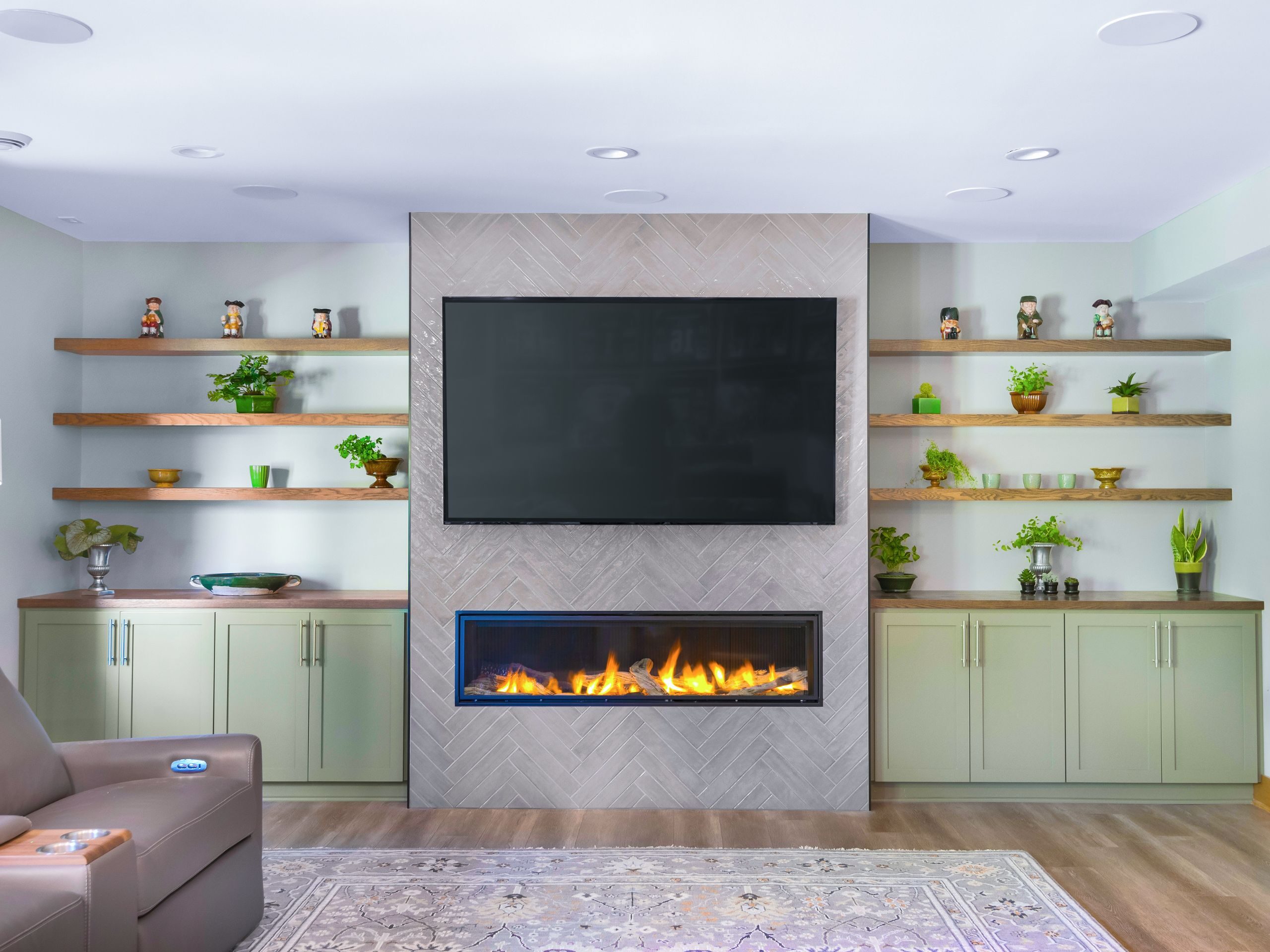 lower level with green cabinetry built in and TV and fireplace