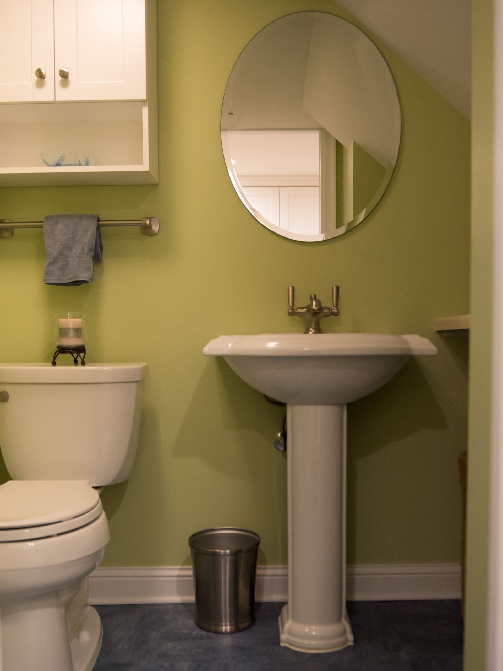 basement remodeling ideas: Green basement bathroom with toilet, sink and mirror