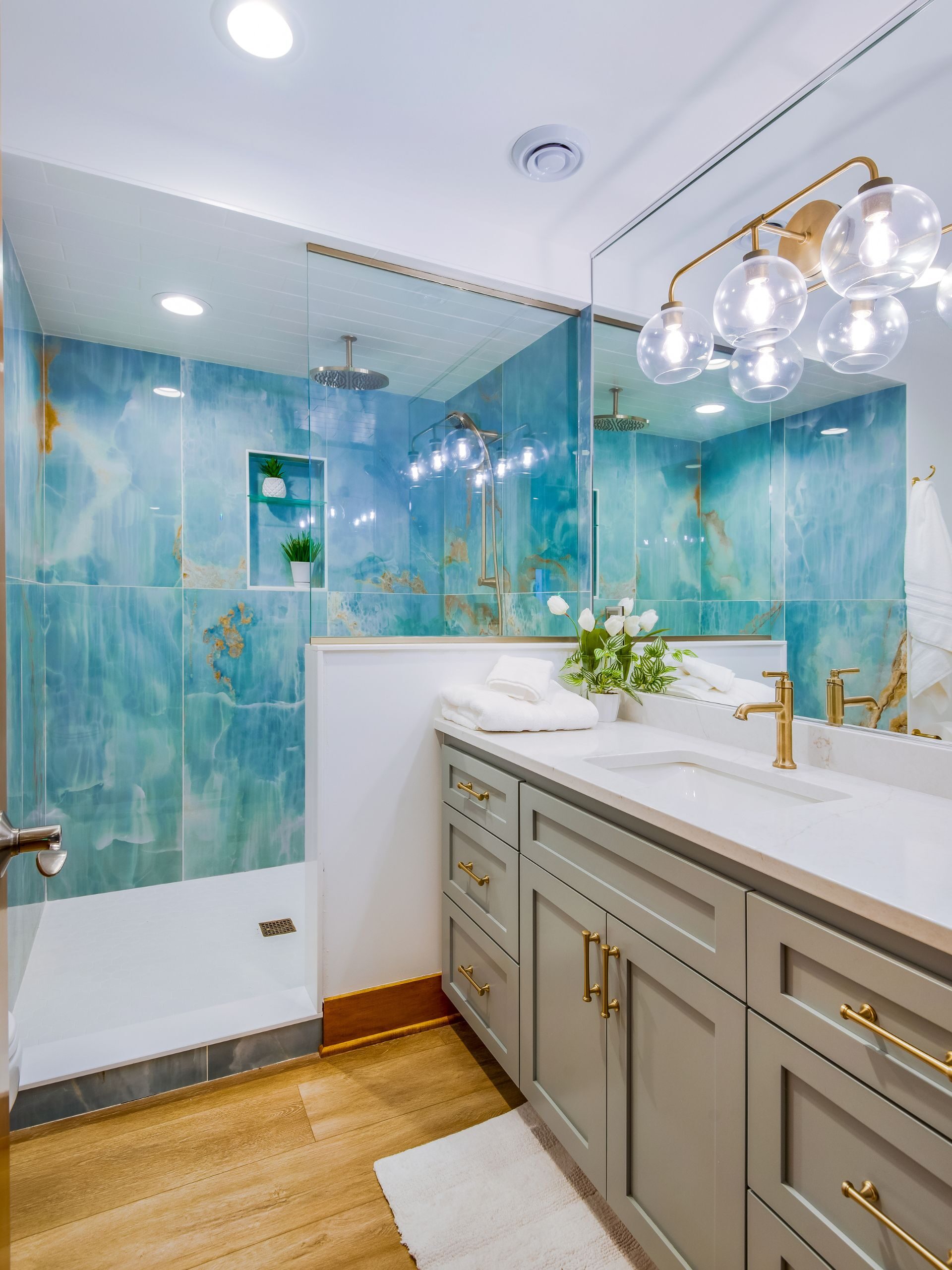 bright blue bathroom with glass and grey vanity