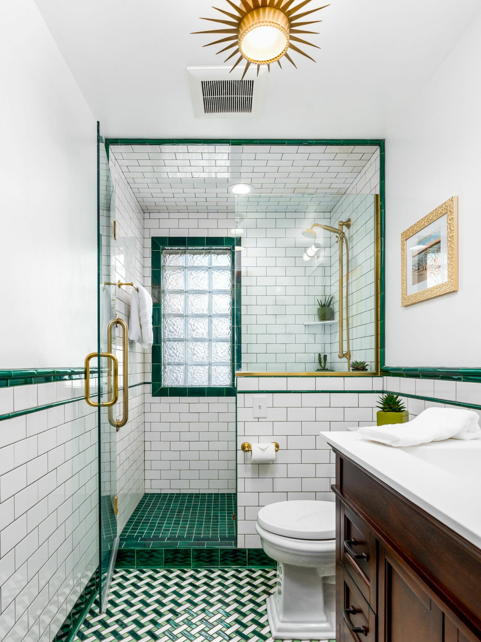 green bathroom design with gold brass light fixture